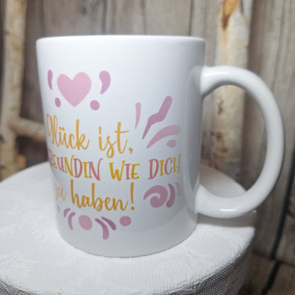 Freundinnen-Tasse in seitlicher Ansicht mit gelb-rosa Spruch, rosa Zierelementen und Henkel rechts.